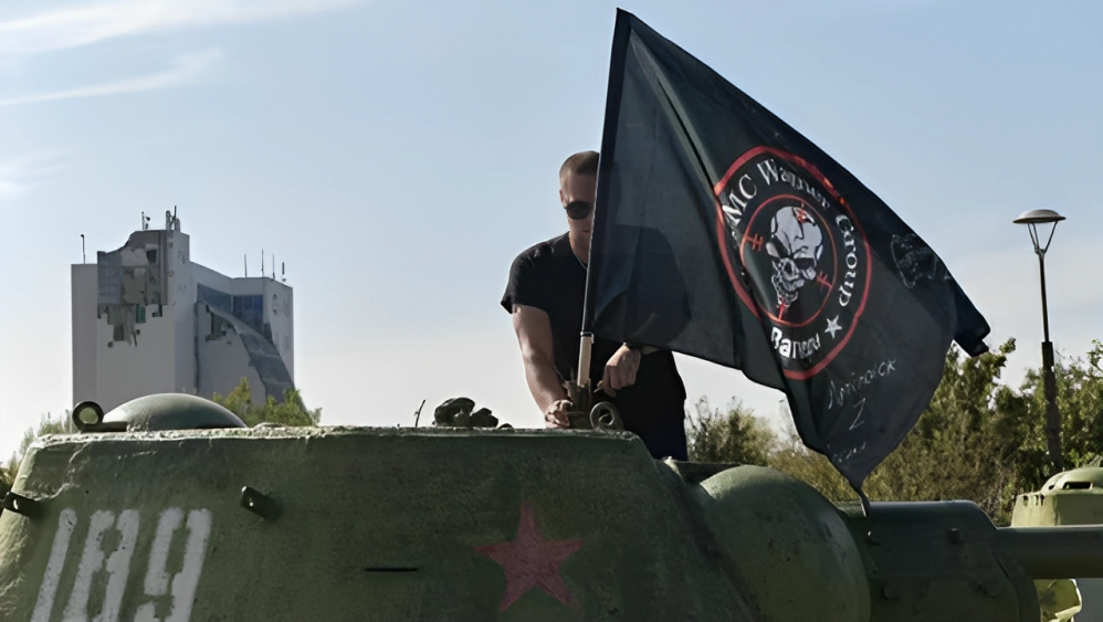 On October 1, 2023, a man in Donetsk, Russian-controlled Ukraine, affixes a banner of the Wagner group to an ancient tank on display at the Leninist Komsomol park.(Image Credit Hindustan Times)