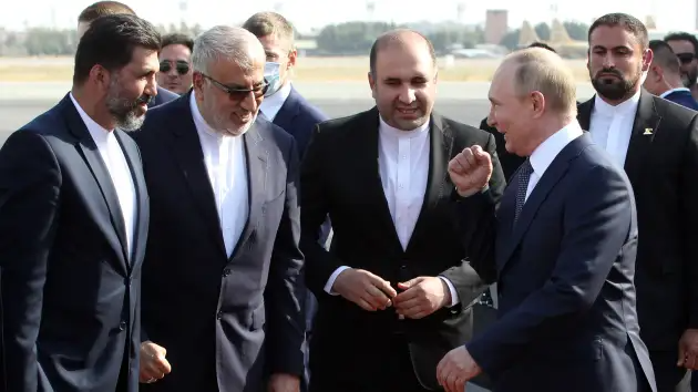 Russian President Vladimir Putin gestures as Iranian Minister of Petroleum Javad Owji (second from left) looks on during the welcoming ceremony at the airport on July 19, 2022, in Tehran, Iran.
